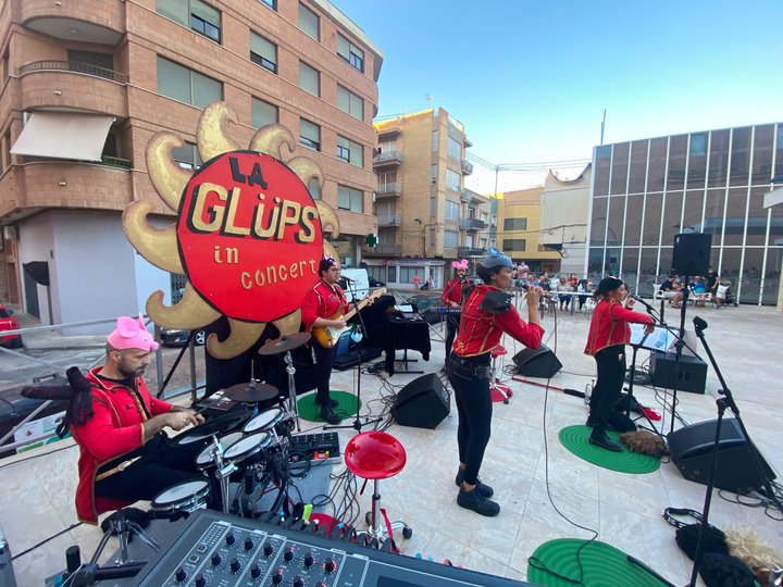 Imagen de 5 personas en una banda tocando en un escenario con el cielo de fondo