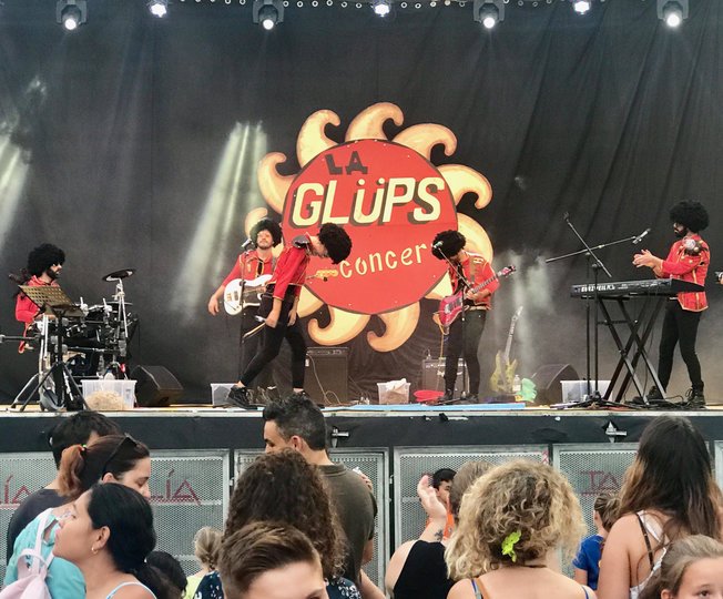 Imagen de 5 personas con pelucas en una banda tocando en un escenario