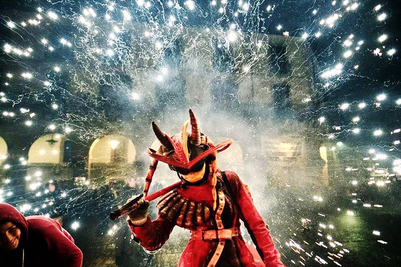 Imagen de una persona caracterizada de demonio iluminada por chispas