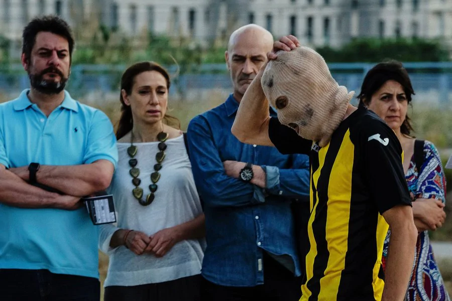 Imagen de gente viendo a una persona en pasamontañas