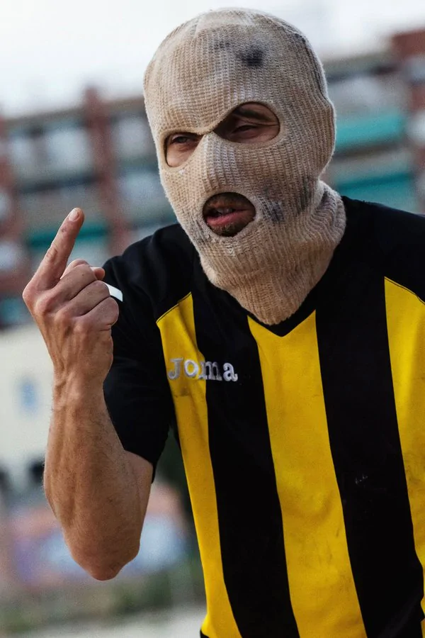 Imagen de una persona con una pasamontañas con una camiseta a rayas amarilla y negra