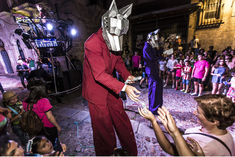 imagen de un espectáculo de noche con personas disfrazadas y el público